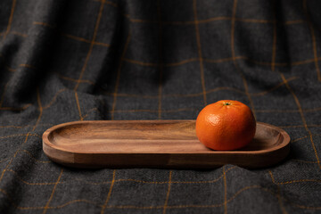 Fresh clementine on wooden bowl and cloth. Healthy fruits and tasty food.