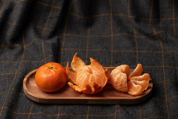 Fresh clementine on wooden bowl and cloth. Healthy fruits and tasty food.