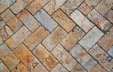 Gray brown stone pavers background. Neutral texture of a flat brick wall close-up.        