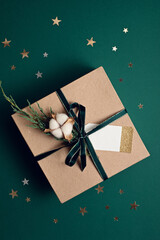 Christmas background with gift box wrapped in kraft paper. Xmas celebration, preparation for winter holidays. Festive mockup, top view, flat lay in natural colos