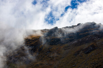 a beautiful landscape with fog on the mountain slope