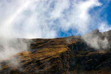 landscape with fluffy clouds on the mountain tops