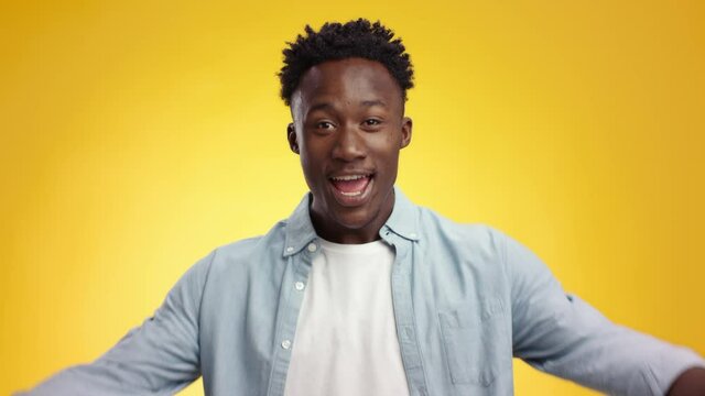 Happy excited african american guy waving hand to camera and calling to hug, expressing sincere gladness from greeting
