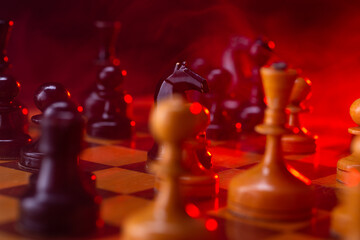 Chess fight, chess pieces on the board, toned in red. Battle fire and smoke