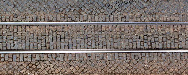 Metal tram rails on the cobblestone pavement. View from above