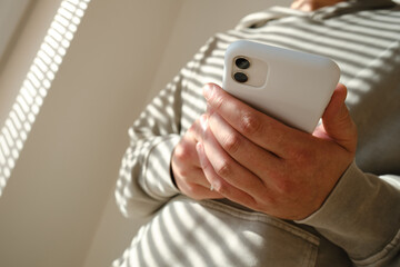 A man is holding a modern smartphone, sending a text message or using an application on his mobile phone. Business concept. Smartphone close-up. Focus on the phone screen