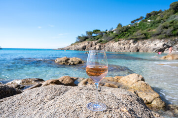 Summer time in Provence, glass of cold rose wine on sandy beach and blue sea near Saint-Tropez, Var department, France - obrazy, fototapety, plakaty