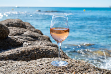 Summer time in Provence, glass of cold rose wine on sandy beach and blue sea near Saint-Tropez, Var department, France