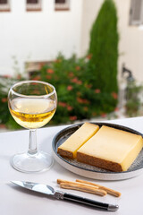 Cheese collection, hard French cheese comte made from  cow milk with rind in Franche-Comte region, France served with white wine