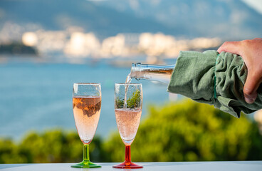 Summer party, pouring of French champagne sparkling wine in glasses with view on fishermen harbour of Toulon, France