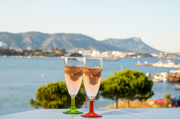 Summer party, drinking of French champagne rose sparkling wine in glasses with view on fishermen...