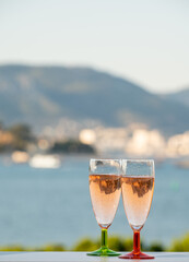 Summer party, drinking of French champagne rose sparkling wine in glasses with view on fishermen harbour of Toulon, France