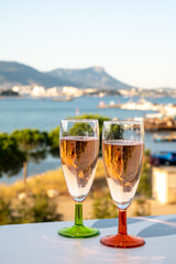 Summer party, drinking of French champagne rose sparkling wine in glasses with view on fishermen harbour of Toulon, France