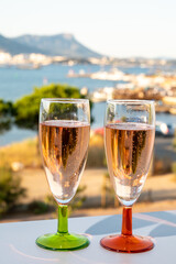 Summer party, drinking of French champagne rose sparkling wine in glasses with view on fishermen harbour of Toulon, France