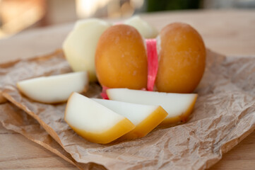 Cheese collection, variety of Italian cow milk cheese scamorza with Italian houses on background