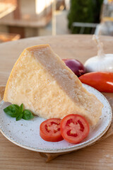 Cheese collection, piece of matured cow cheese pasmesan parmigiano reggiano and Italian houses on background