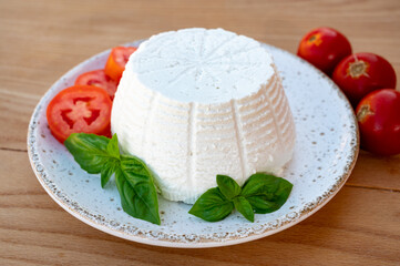 Cheese collection, white Italian soft cheese ricotta served with fresh tomatoes and basil