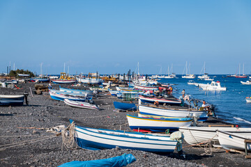 Fototapeta na wymiar Stromboli island (Aeolian archipelago), Lipari, Messina, Sicily, Italy, 08.21.2021: view of the village with many boats on the black lava beach.