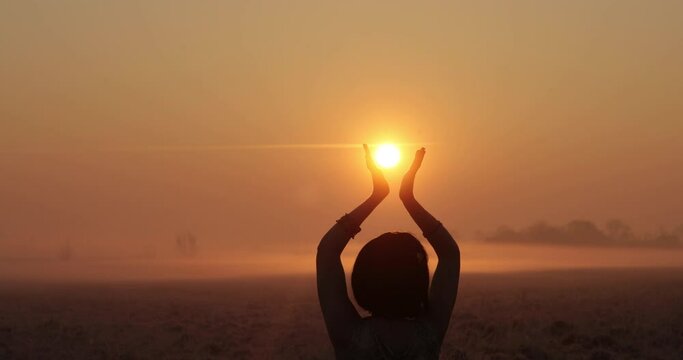 girl dancing at sunset. hands playing with the sun like a ball. beautiful sunset. girl sexually moves in the field at sunset. slim lady silhouette at sunset.