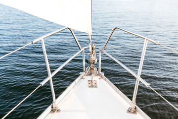 Naklejka na ściany i meble Stern with a sail of a white yacht. Close-up of the yacht.