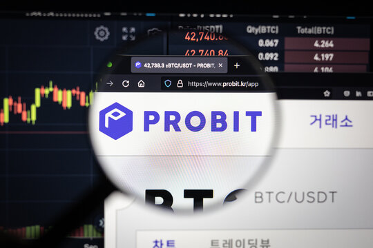 Probit cryptocurrency exchange logo on a website with blurry stock market developments in the background, seen on a computer screen through a magnifying glass