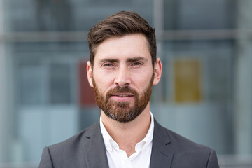 freelancer man serious looking at camera, close-up portrait of a man in a business suit