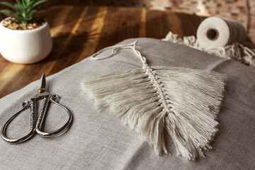 Weaving macrame from natural cotton threads. Home decor in vintage boho style. © Лариса Ильина