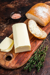 Butter spread and foodstuff toasts on a wooden cutting board. Dark background. Top view