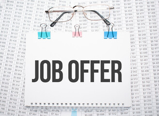 Job offer text written on paper with pen and glasses