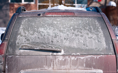 Salt stains on rear car window, bad visibility, dangerous driving in winter season. Dirty car...