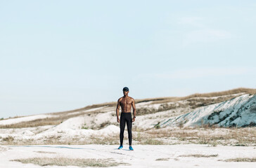 sporty black man, fitness man, muscular man with naked torso outdoors in nature
