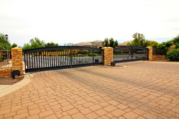 Two Iron Entry And Exit Electric Gates  With Pavers Driveway
