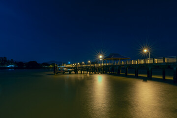 Fototapeta na wymiar Long exposition night image of Rawai pier on phuket island in Thailand with silky looking water