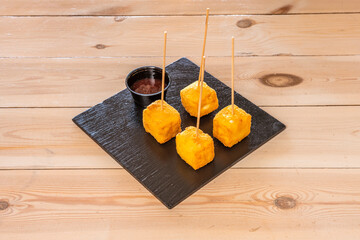 Brie cheese tacos or lollipops battered in breadcrumbs with egg fried in olive oil with dip sauce