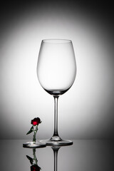 Wine glass and glass flower on gradient background