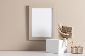 Photo frame mockup on beige wall and wooden mannequin with Christmas decoration, gifts. Xmas or winter concept. Front view