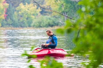 A solo canoeist practices stroke techniques on a rainy fall day as part of a “moving water” paddling course. Shot on the Madawaska River an iconic paddling destination in Eastern Ontario, Canada.