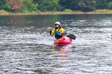 A solo canoeist practices stroke techniques on a rainy fall day as part of a “moving water” paddling course. Shot on the Madawaska River an iconic paddling destination in Eastern Ontario, Canada.