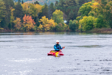 A solo canoeist practices stroke techniques on a rainy fall day as part of a &ldquo;moving water&rdquo; paddling course. Shot on the Madawaska River an iconic paddling destination in Eastern Ontario, Canada.