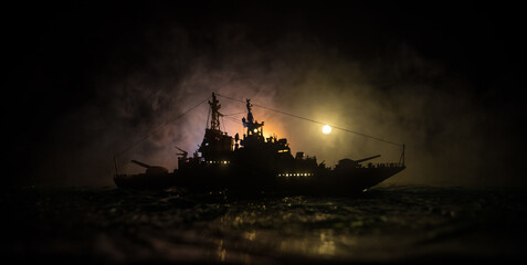 Silhouettes of a crowd standing at blurred military war ship on foggy background. Selective focus.