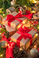 Gift boxes with red ribbons, Christmas tree toys and lights. Merry Christmas and Happy New Year. Side view, vertical.