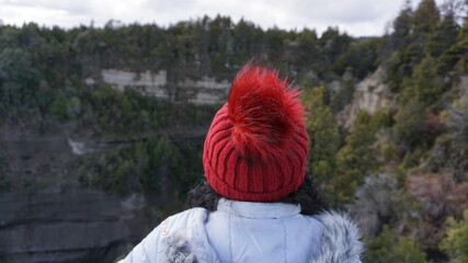 Mujer con gorro rojo mira el horizonte 