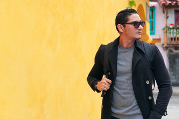 Portrait of a handsome latin hipster walking down the street. Lifestyle concept
