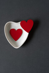 Obraz premium two red hearts on a gray black background