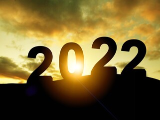 Happy New year 2022 with large silhouette letters on the mountain with sunset light,