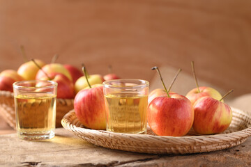 Fresh red apple fruit and juice in a basket on wooden background