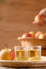 Fresh red apple fruit and juice in a basket on wooden background
