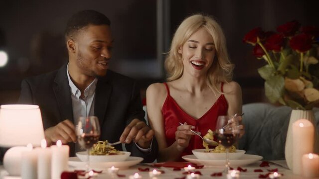 Happy Multiracial Couple Eating Pasta Having Romantic Dinner In Restaurant