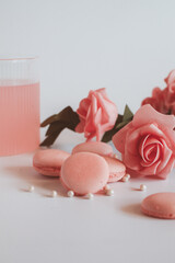 Pink macaroons with bouquet of rose on marble table, pastel colored, Traditional French multicolour macaroon. selective focus. Copy space