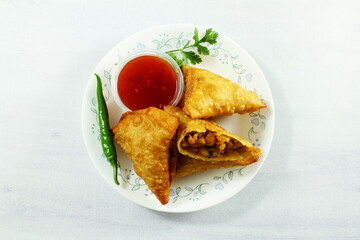 traditional indian gujarati food tea time snack vegetable chana dal samosa with chilli tomato sauce top view